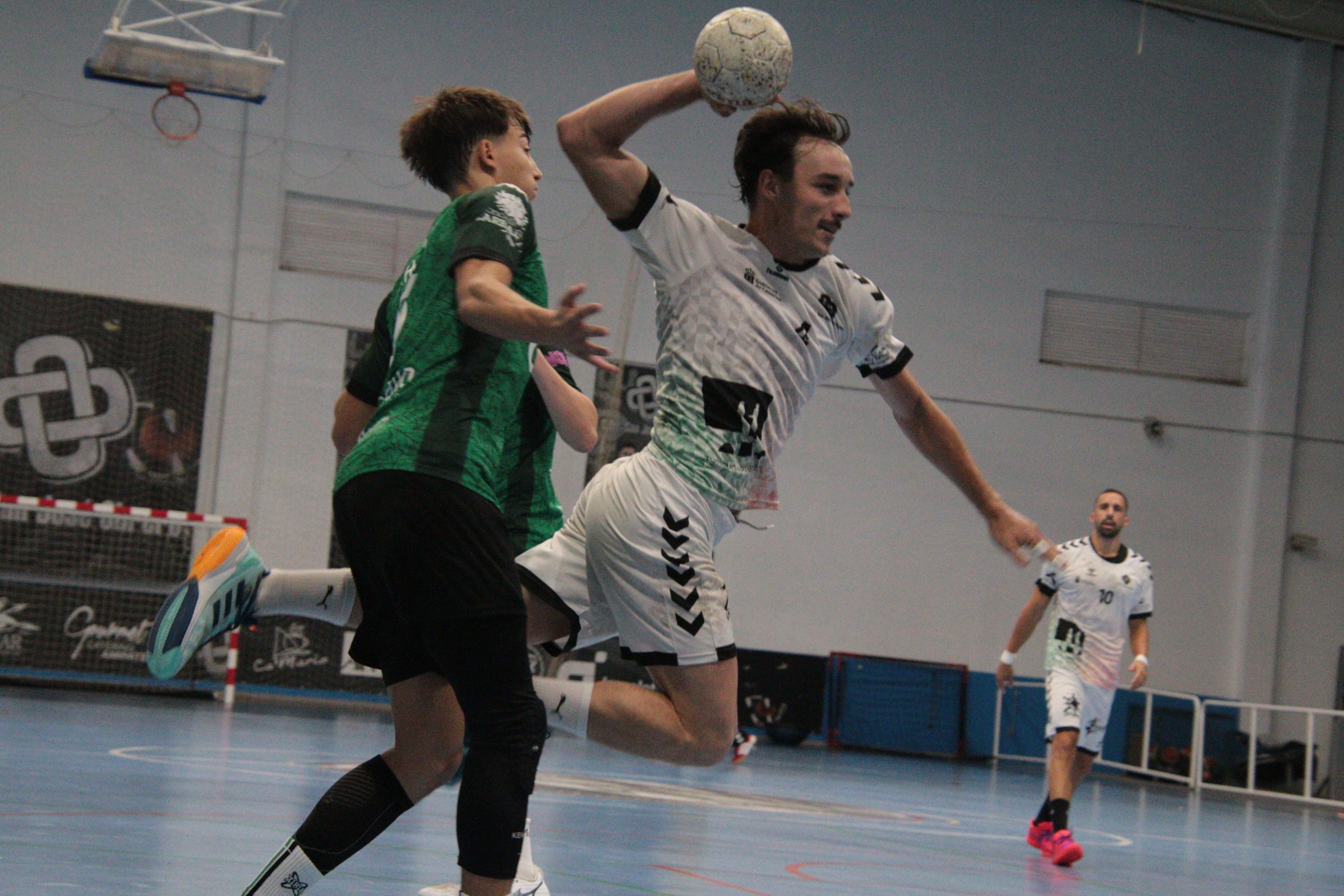 Jugador del Balonmano Lanzarote Ciudad de Arrecife lanza ante la defensa del Calvo Xiria