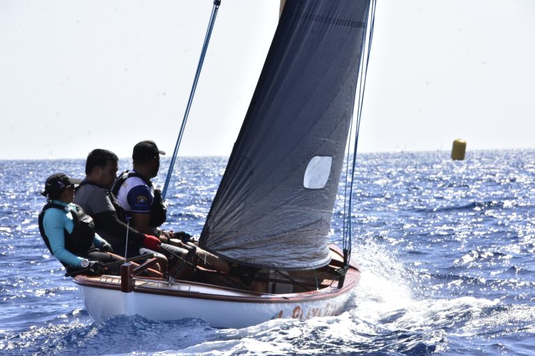 Tripulación de un barquillo de vela latina navegando durante una regata